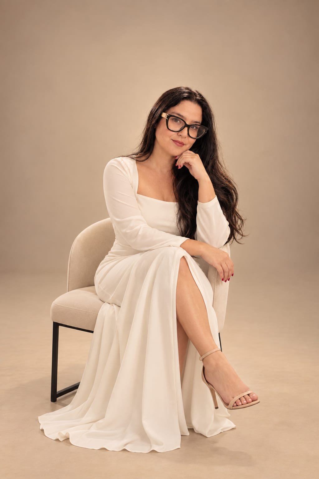 Bruna Lua, fundadora da Escola BY BL, sentada com vestido branco